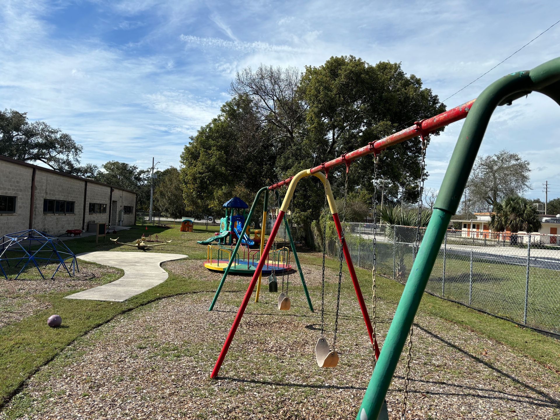 A colorful playground with swings and a slide in a park.