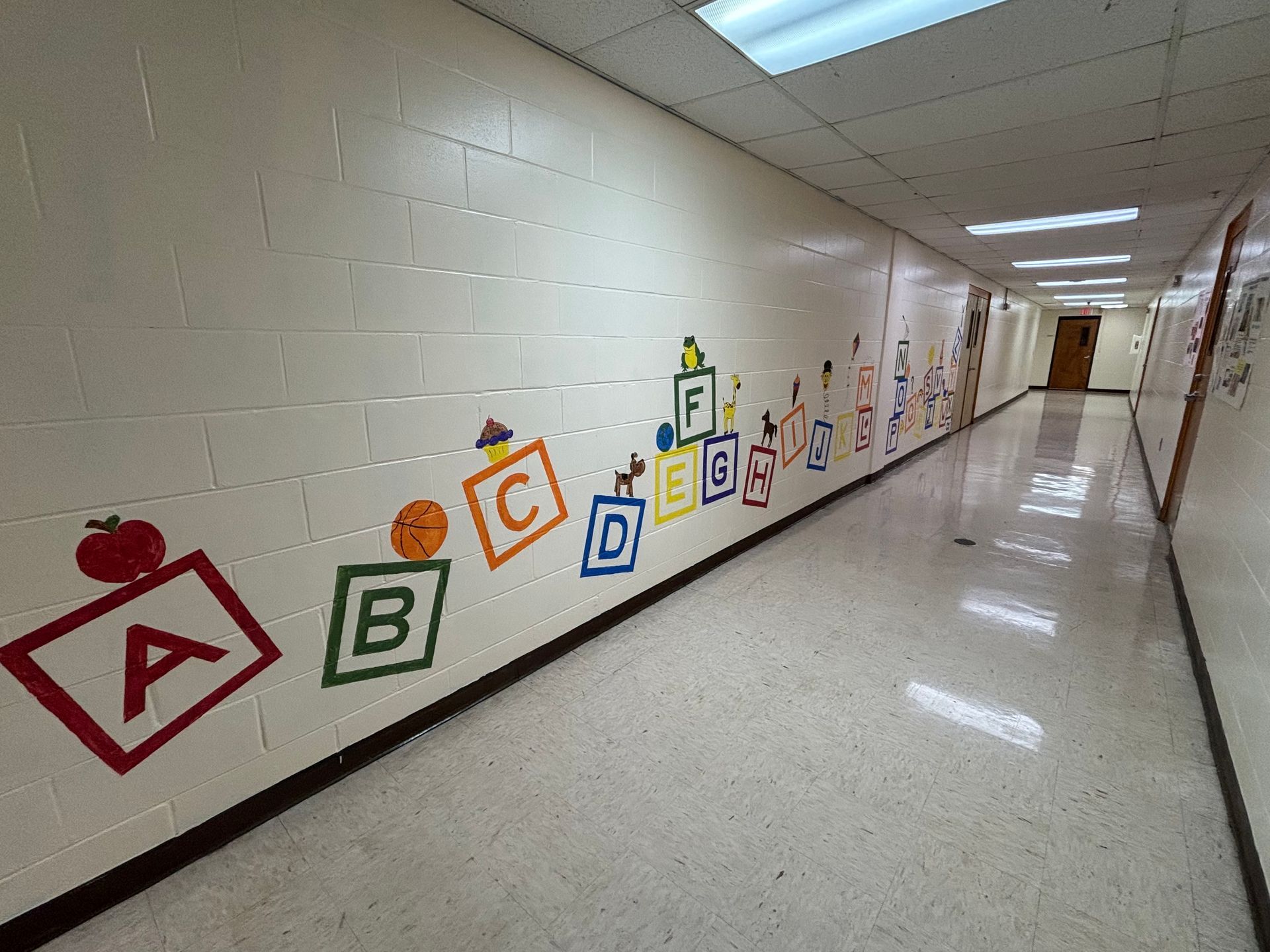 A long hallway with alphabet blocks painted on the wall.