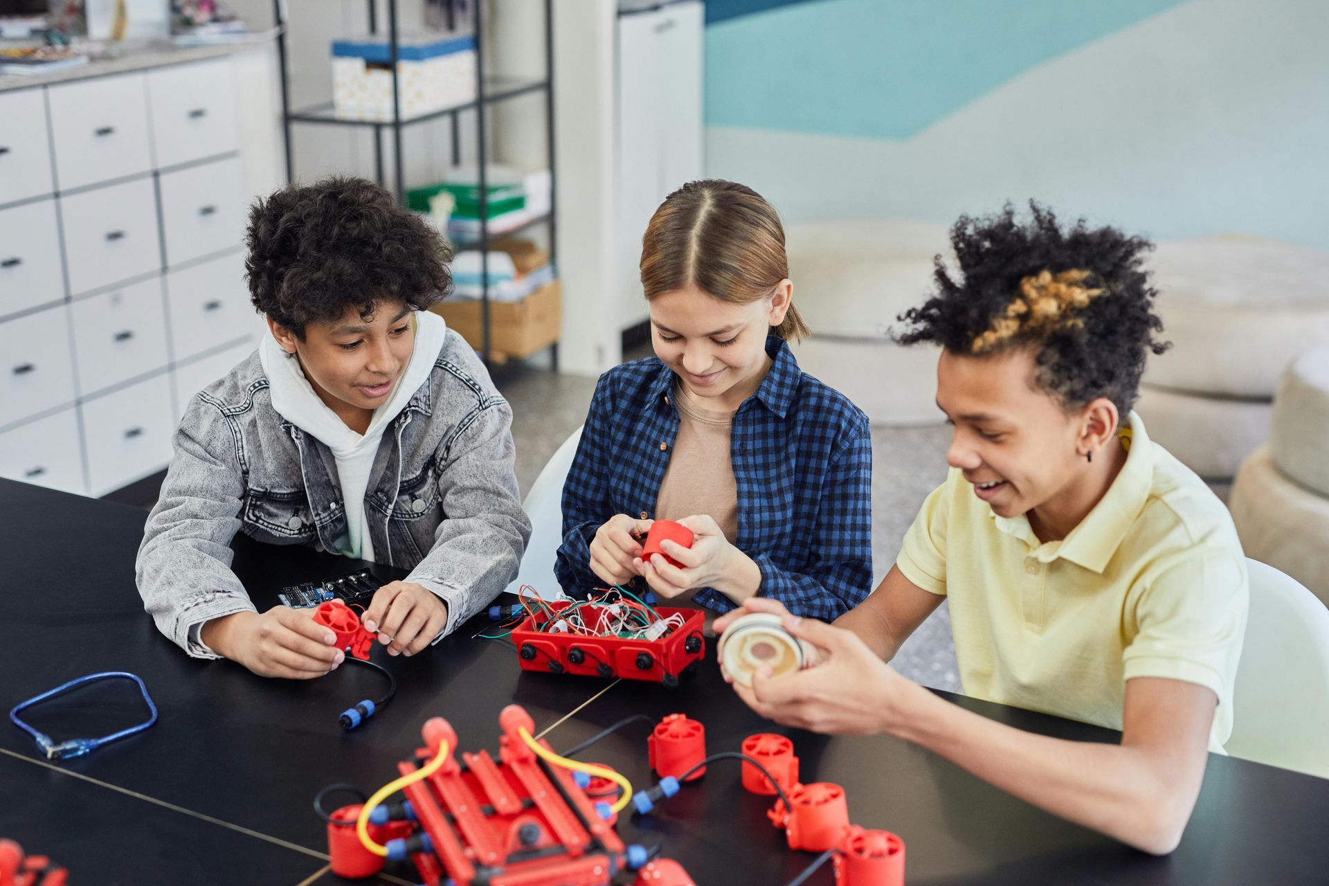 A group of children are sitting at a table playing with toys.