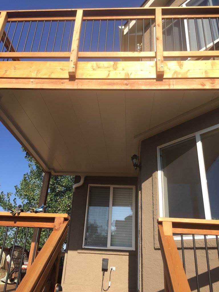Outdoor patio with red sofa, stone fireplace, and dark ceiling.