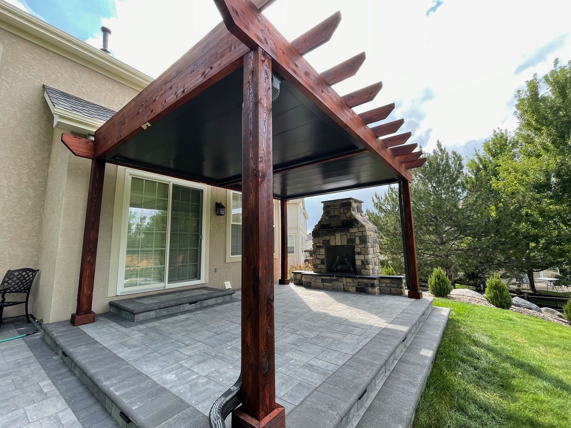 A two-story house with a wooden deck and a covered patio area. Green siding, neutral trim.