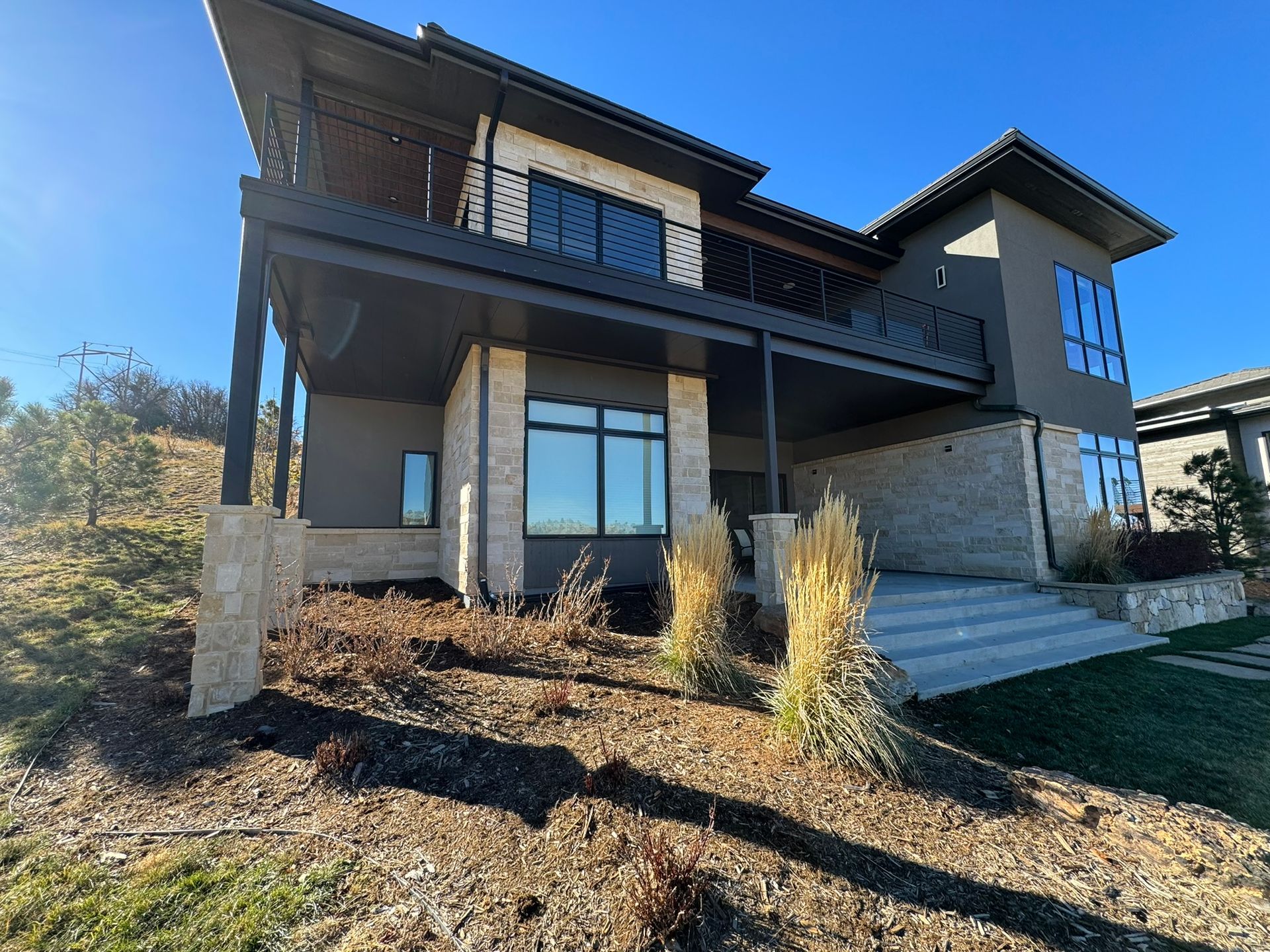 Beige gutter elbow on a brick wall, attached to a porch ceiling with string lights.