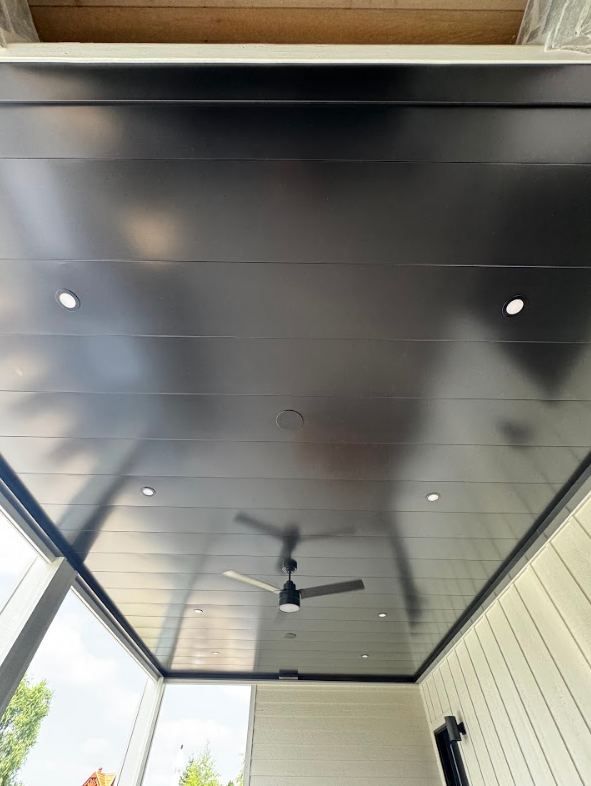 Black ceiling with recessed lights, ceiling fan, and white trim. Exterior view.