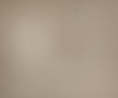 Plain, light beige wall with slight texture and a small dark spot.