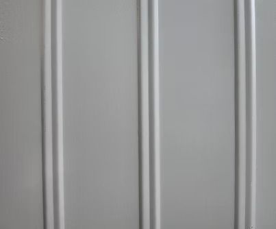 Vertical paneling with a light gray color and raised, rounded lines.