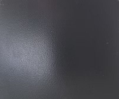 Dark gray textured surface with a light reflection.