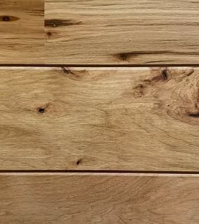 Close-up of wooden floor planks, light brown with knots and grain detail.
