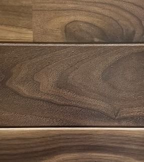 Dark wood grain flooring with prominent swirls and a light-colored seam.