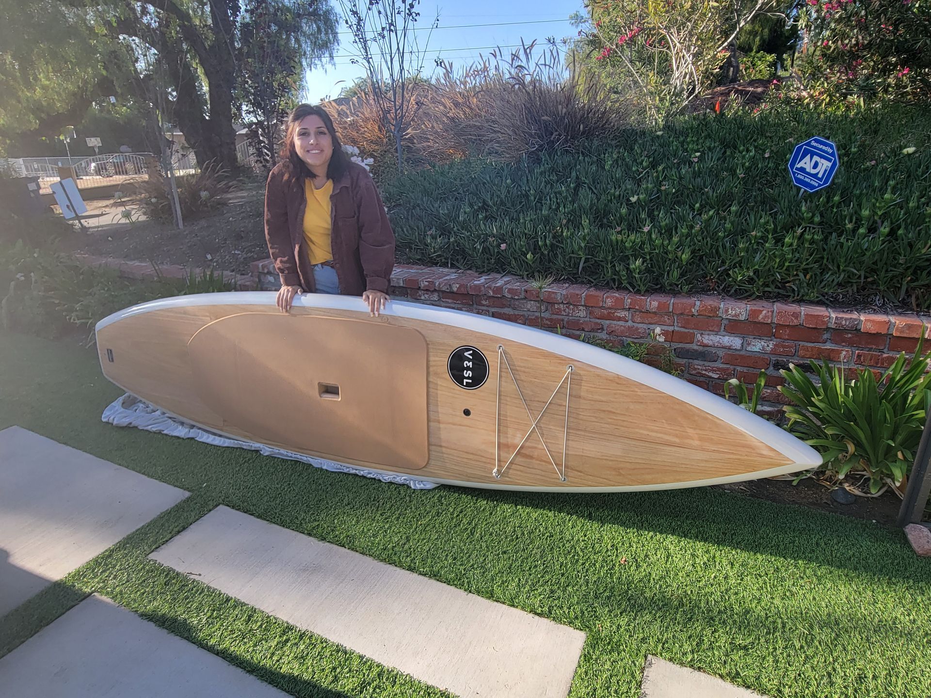 Girl and her paddle board on artificial grass