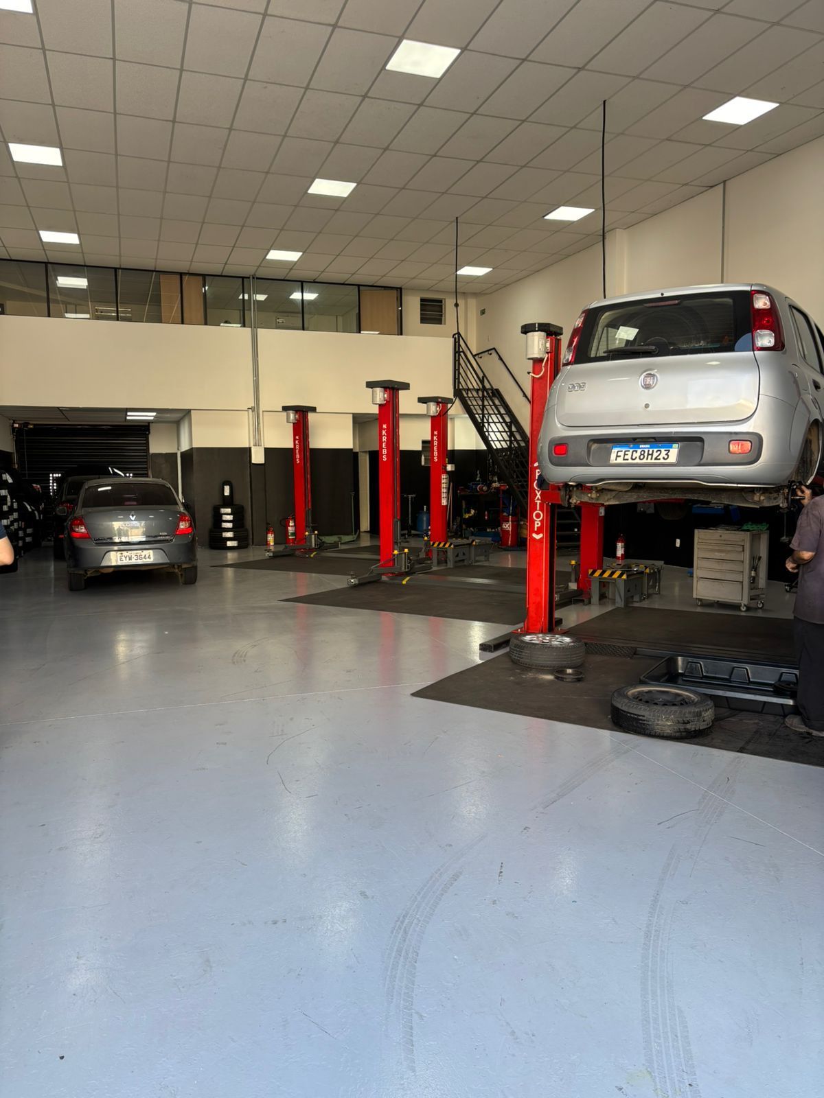 Mulher sentada à mesa em uma loja de pneus Bridgestone, falando ao telefone. 