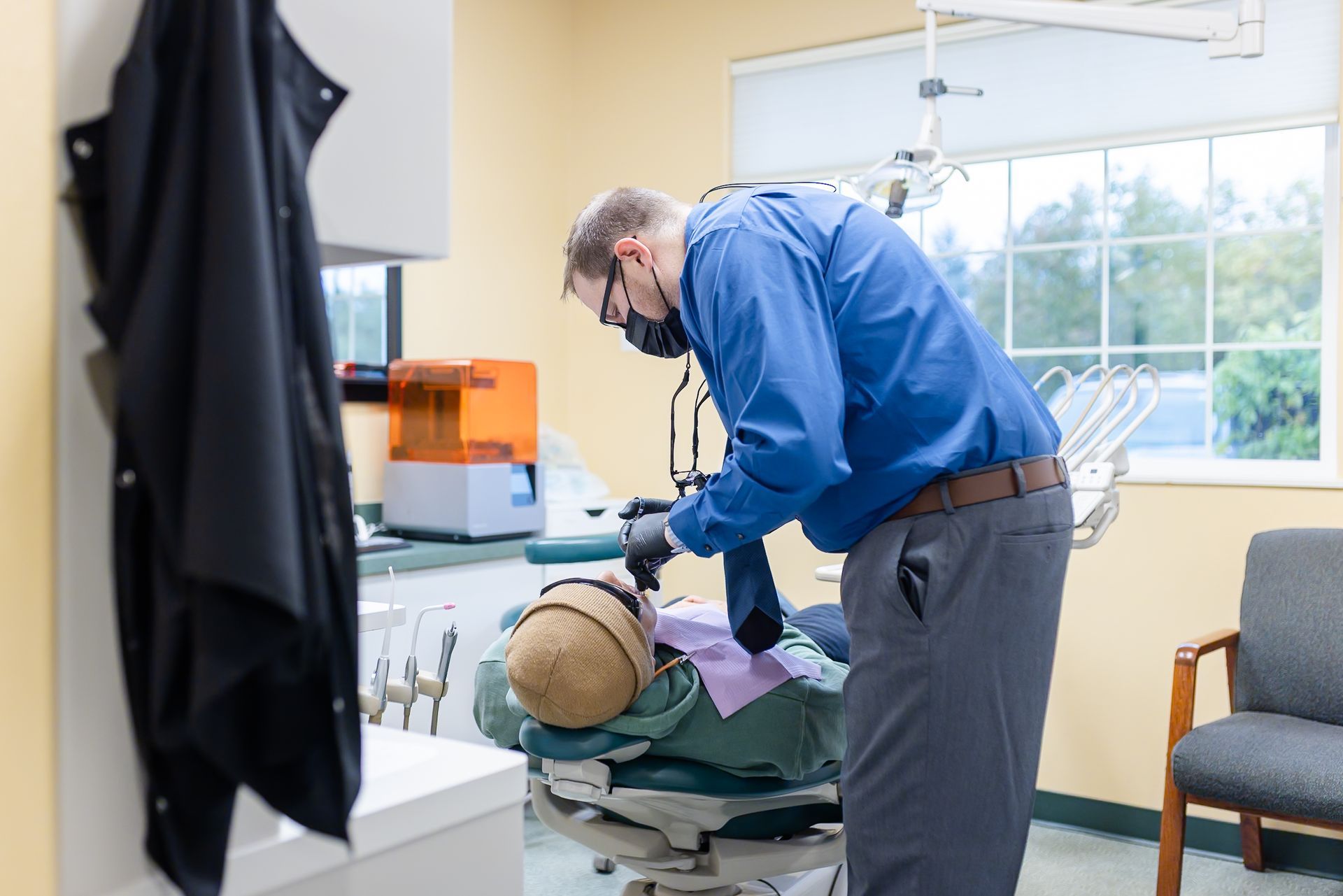 Dentist examining a patient's mouth in a dental office.