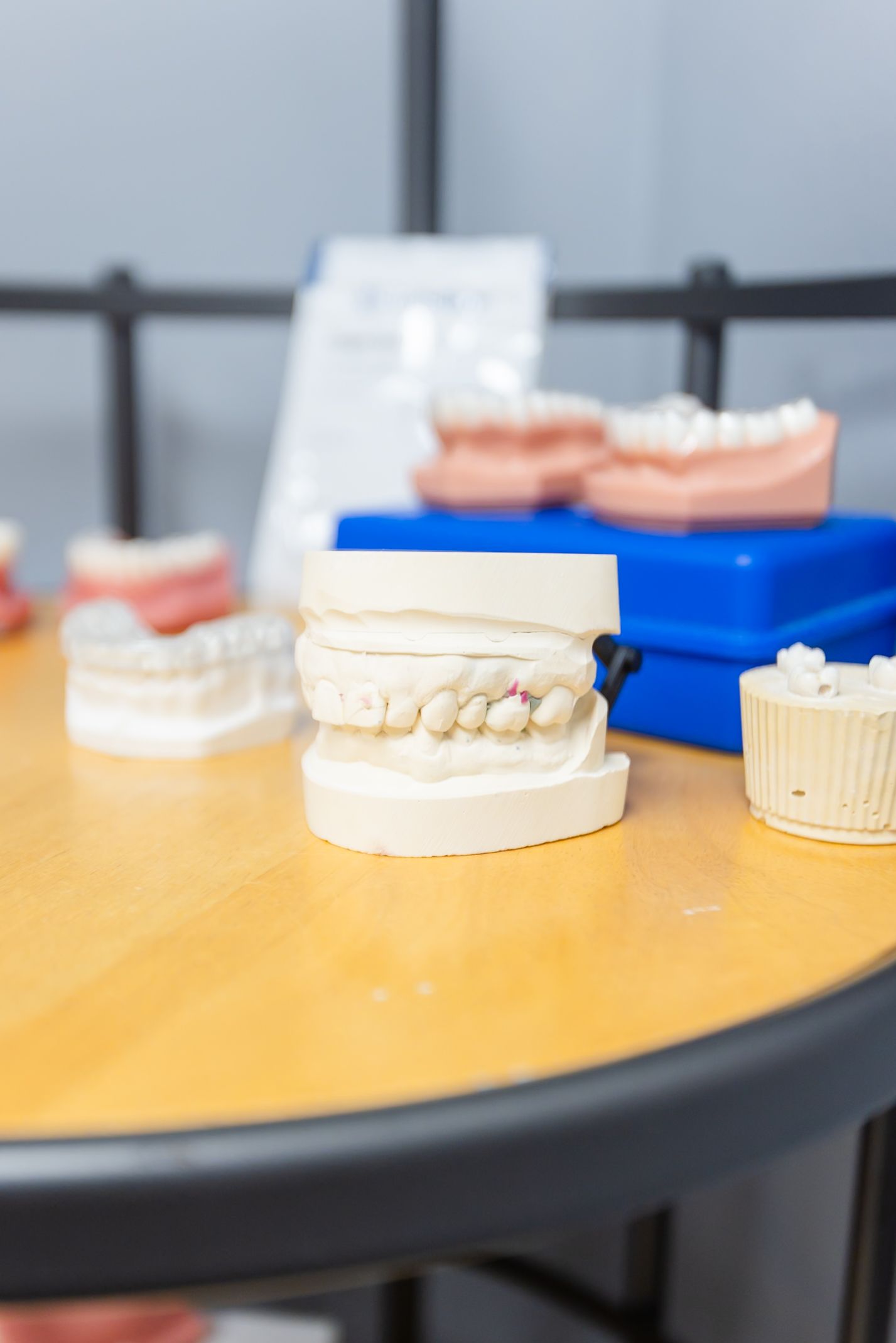 Dental models on a table, including a full set of teeth and other dental tools.