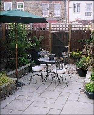 A patio area with a small metal table and chairs in the centre