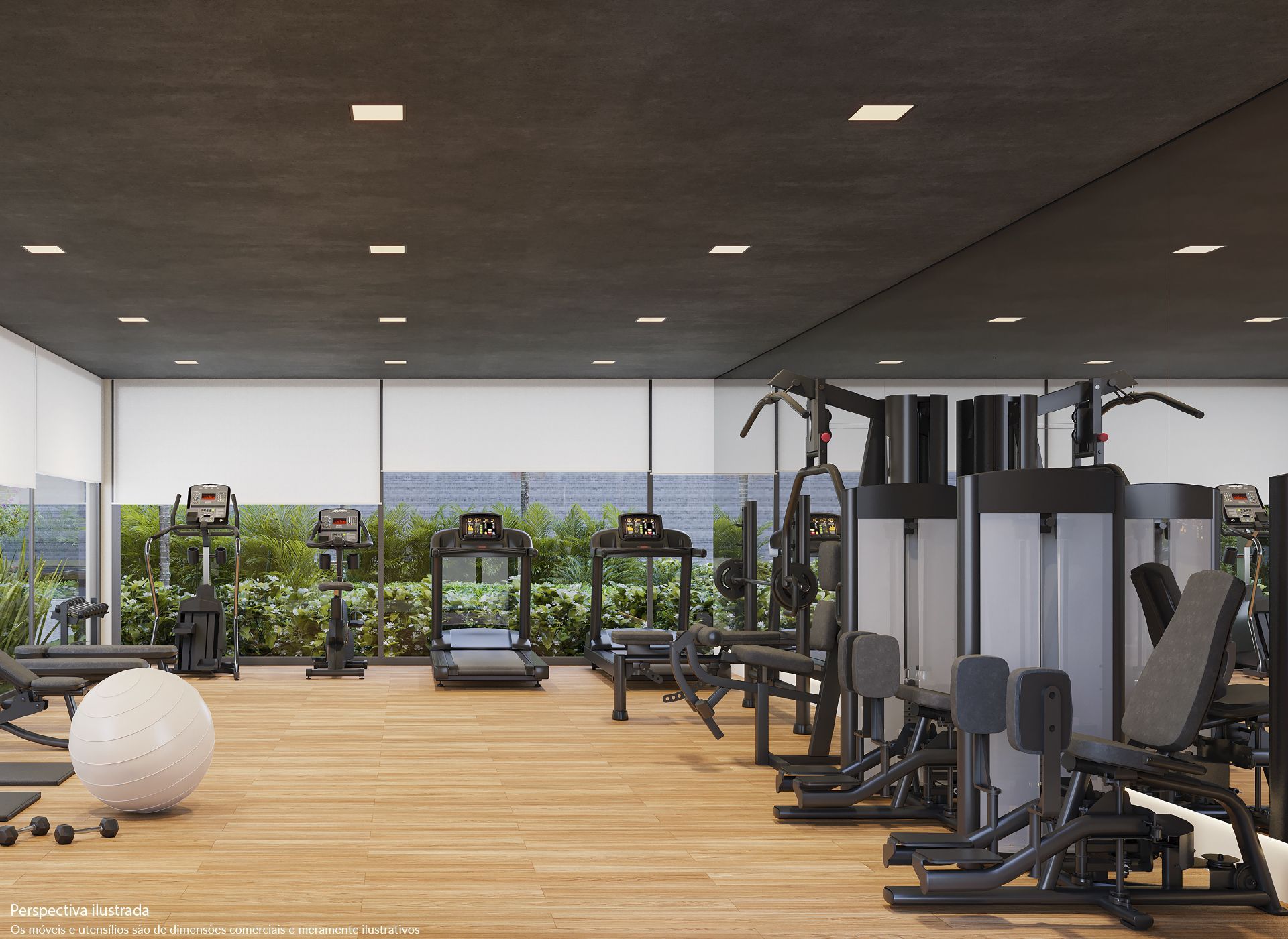 Academia com vários aparelhos de ginástica, bola de equilíbrio e piso de madeira, com janelas com vista para a área verde.