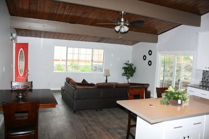 A living room with a couch a table and a ceiling fan
