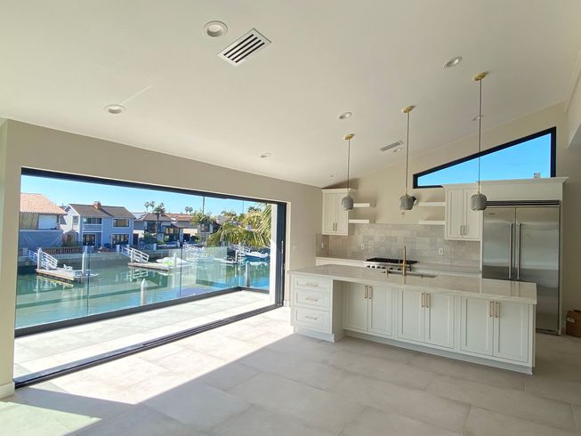 A kitchen with a large window overlooking a body of water.