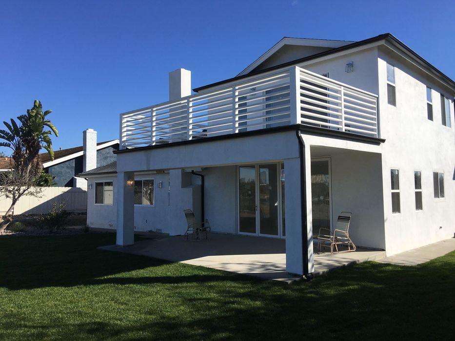 A white house with a balcony on the second floor