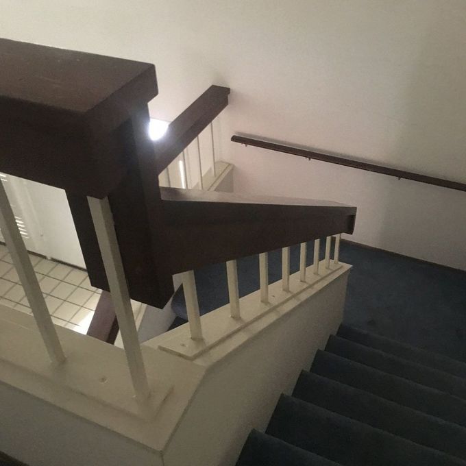 A staircase with a wooden railing and a white railing