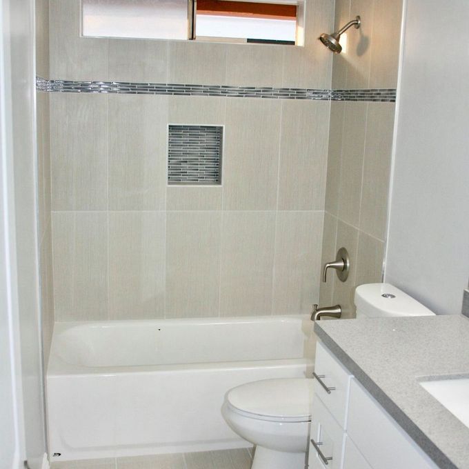A bathroom with a toilet a tub and a window