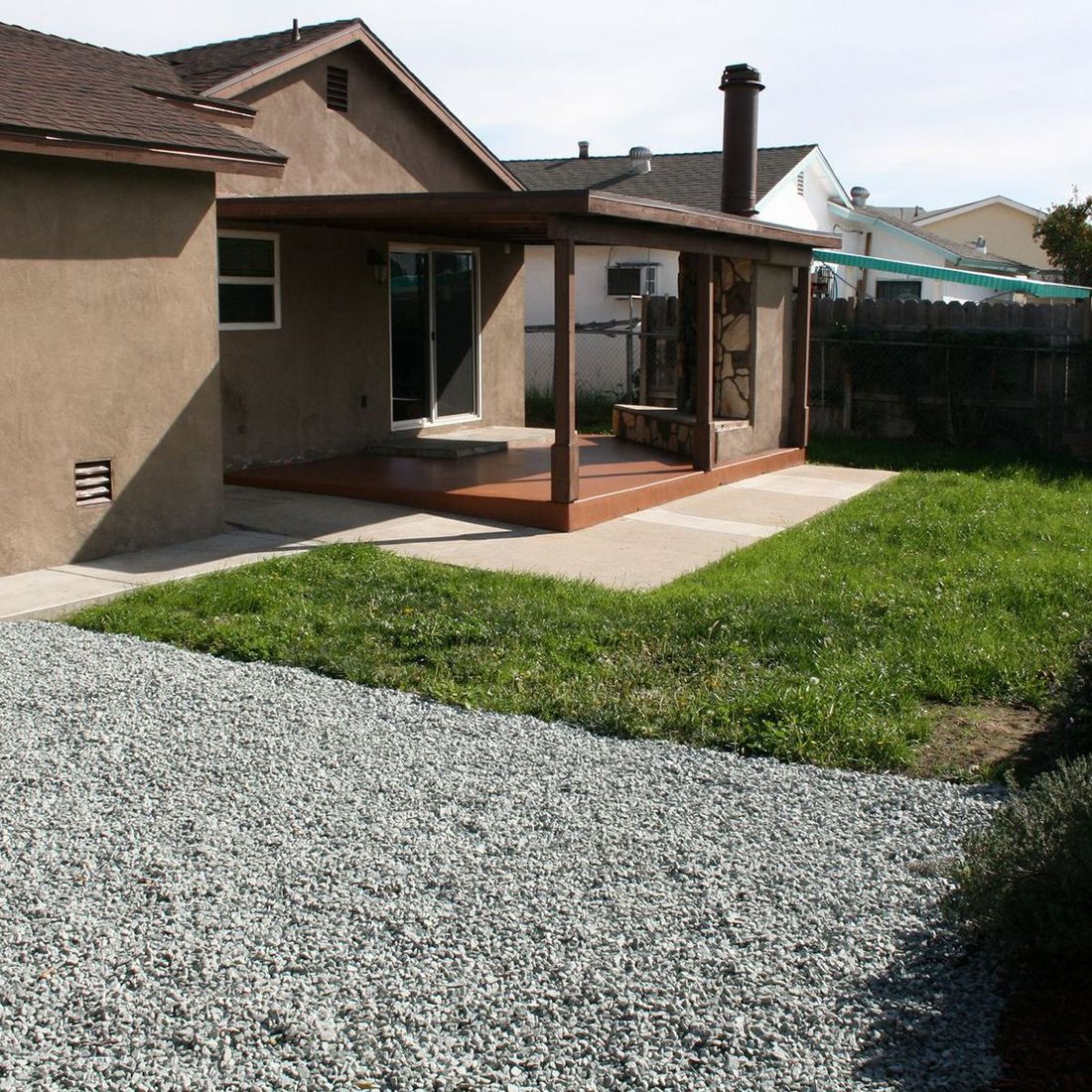 A house with a porch and gravel in front of it