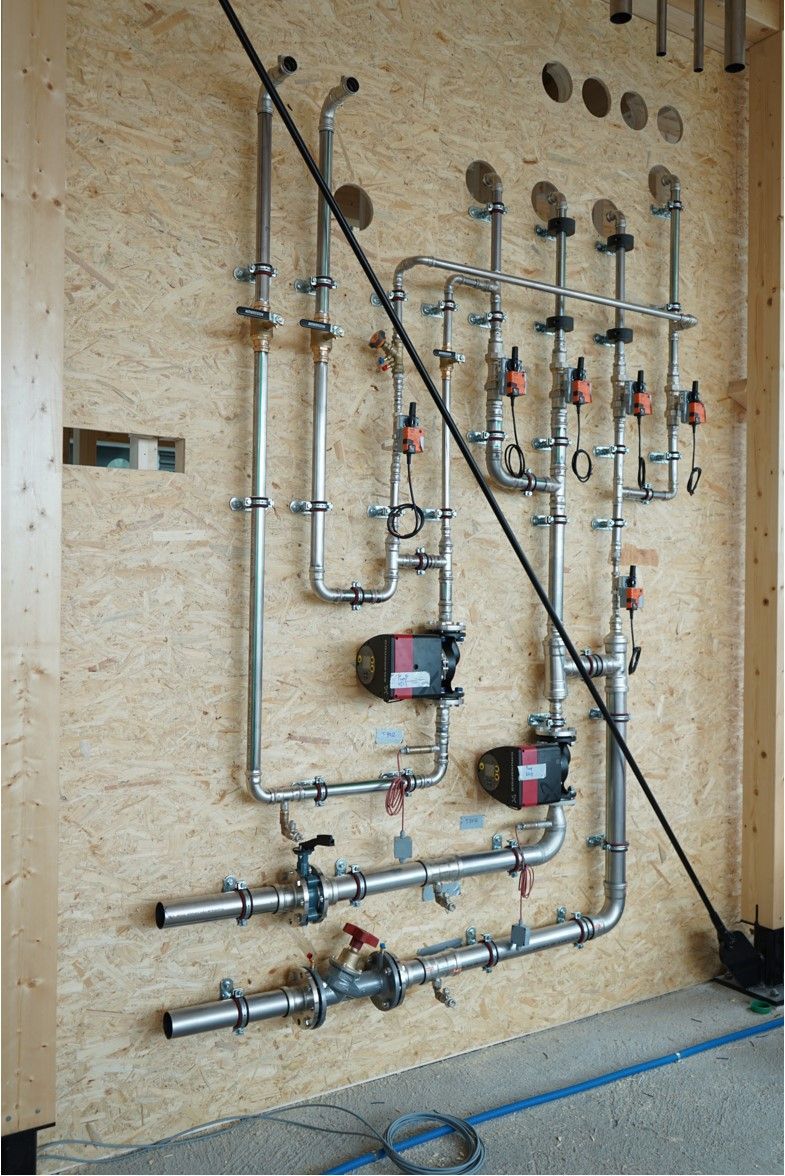 eine Wand mit vielen Rohren an ihr