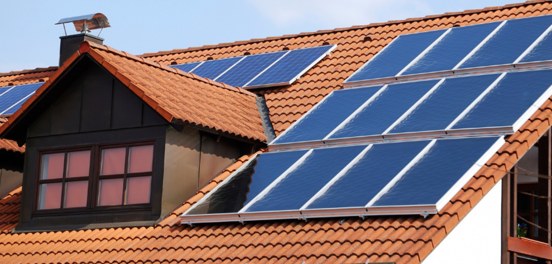 eine Reihe von Sonnenkollektoren auf dem Dach eines Hauses