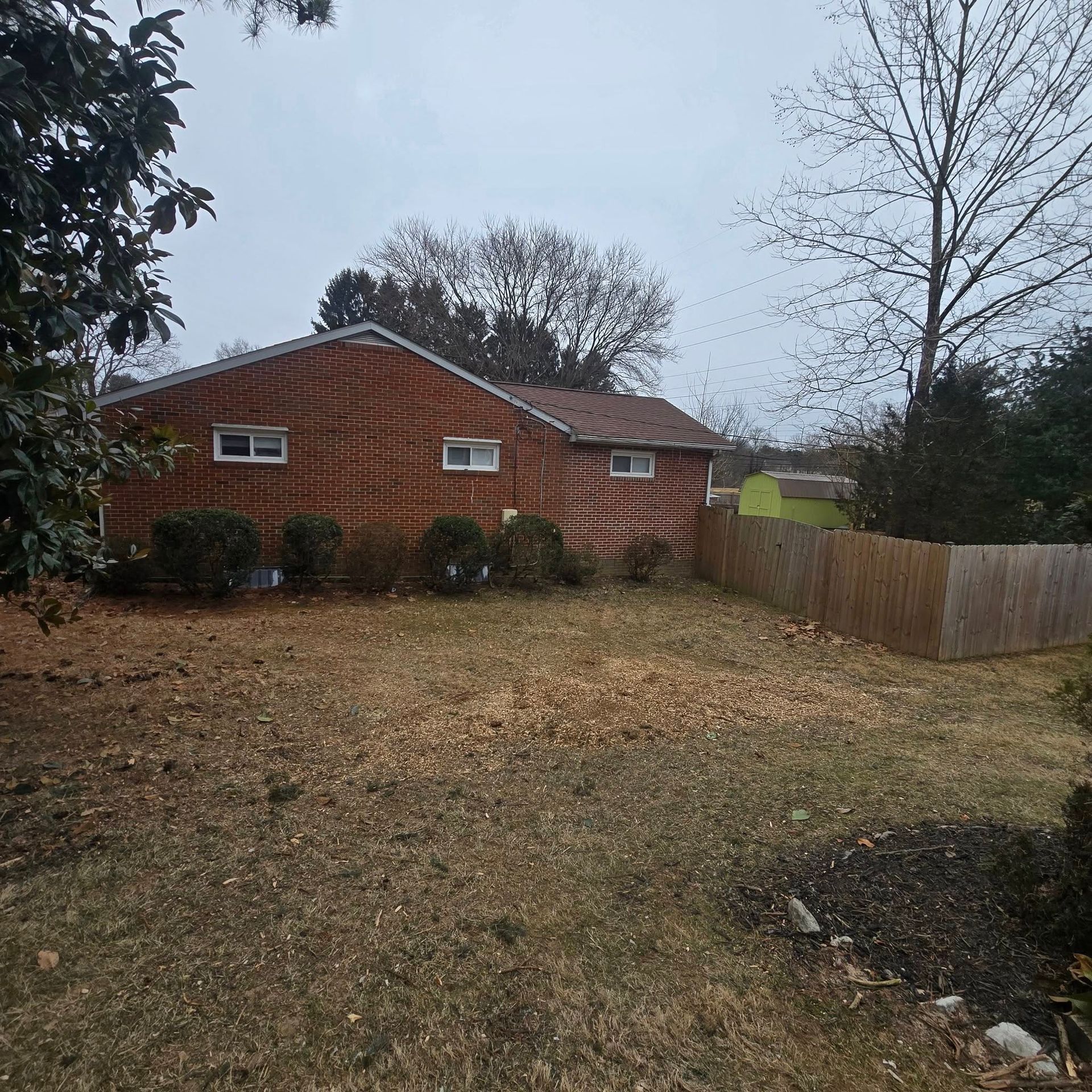 A brick house with a wooden fence in front of it