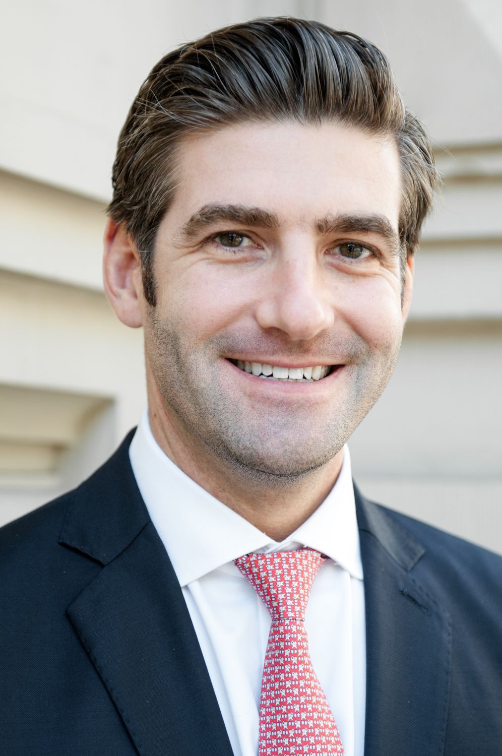 A man in a suit and tie is smiling for the camera