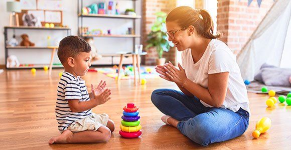 Female Teacher and Toddler Building Pyramid — Alton IL — Toddle Towne Learning Center
