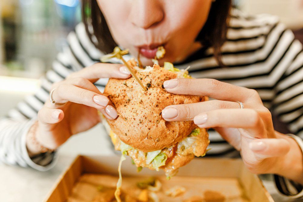 Woman Eating Burger — O'Fallon, MO — Clayton's