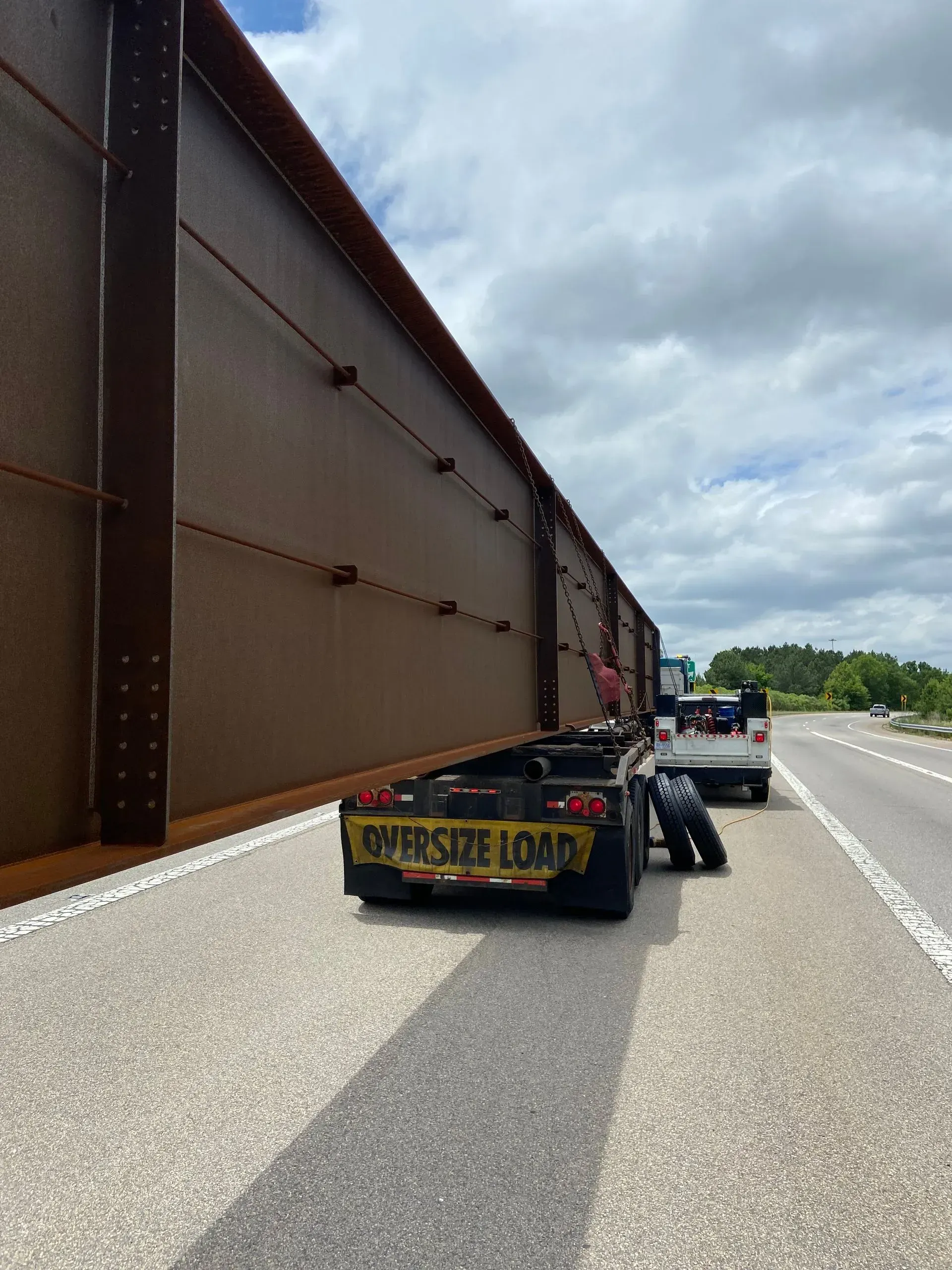 A large trailer is sitting on the side of a highway.