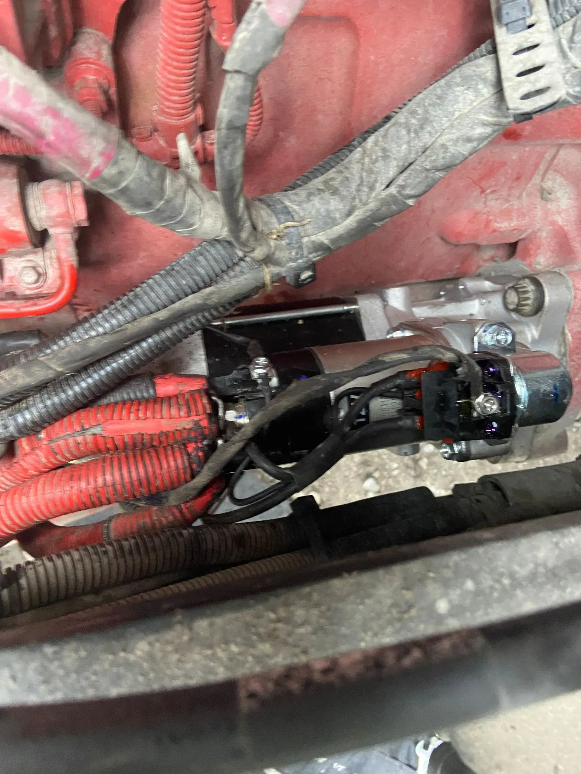 A close up of a car engine with a lot of wires coming out of it.