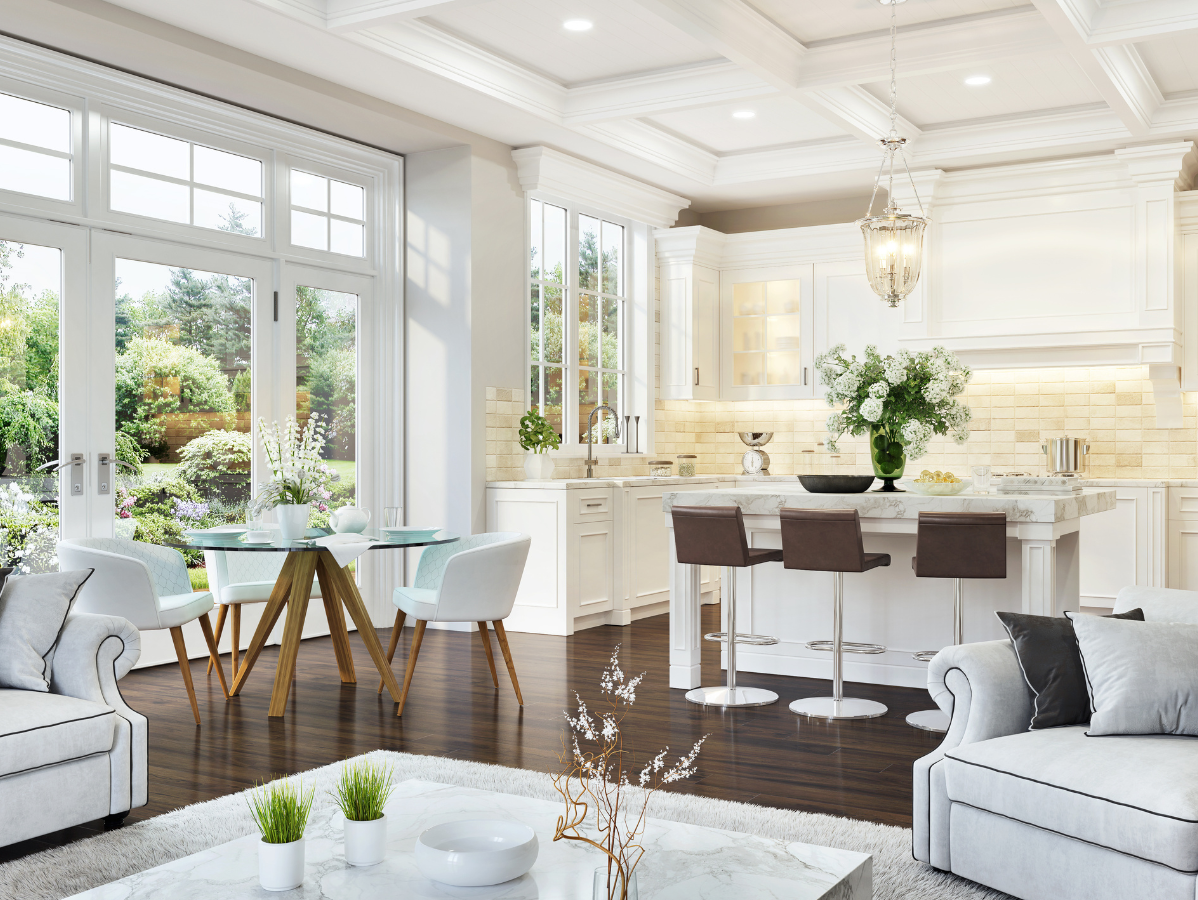 Bright white living space with kitchen. Glass doors look out onto garden.