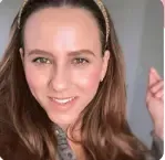 A close up of a woman wearing a headband and smiling.
