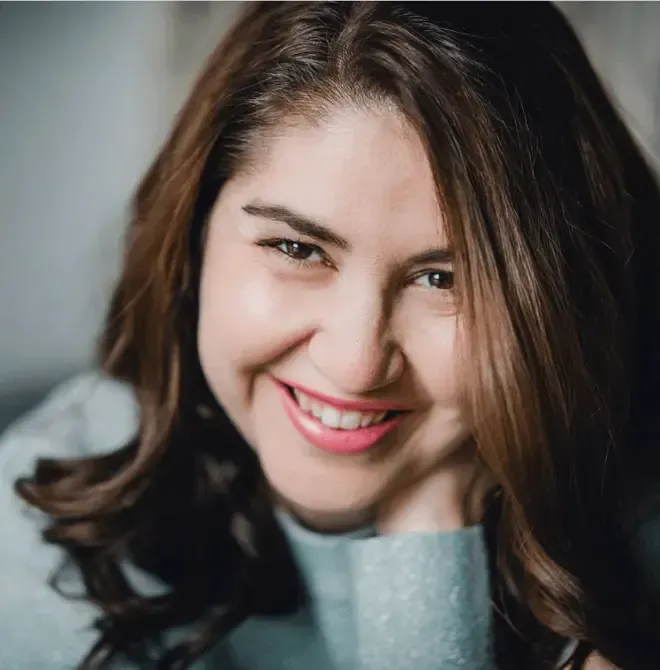 A close up of a woman 's face with a smile on her face