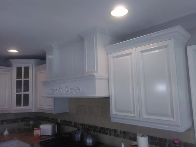 A kitchen with white cabinets and a stove top oven