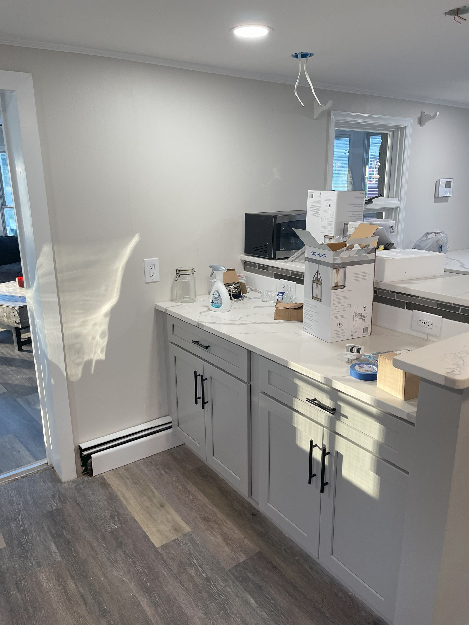Kitchen with white cabinets, light countertops, and appliances.