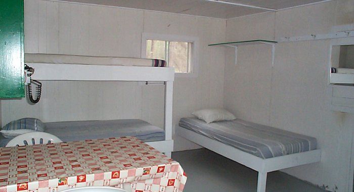 A room with bunk beds and a table with a checkered tablecloth