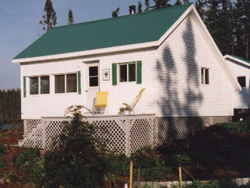 A small white house with a green roof