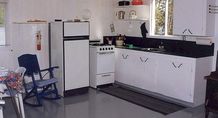 A kitchen with white cabinets and a rocking chair