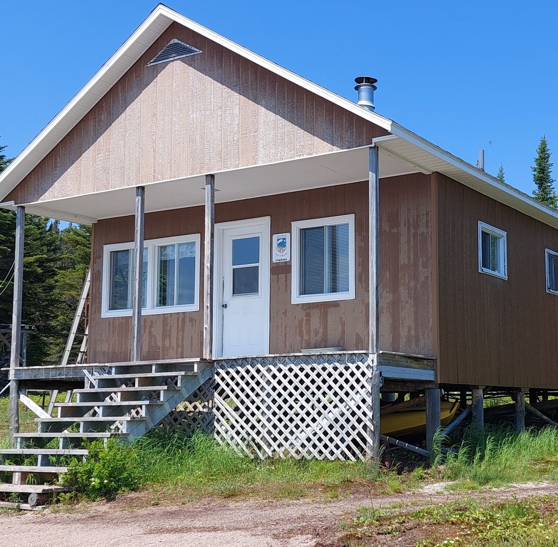 A small brown house with stairs leading up to it