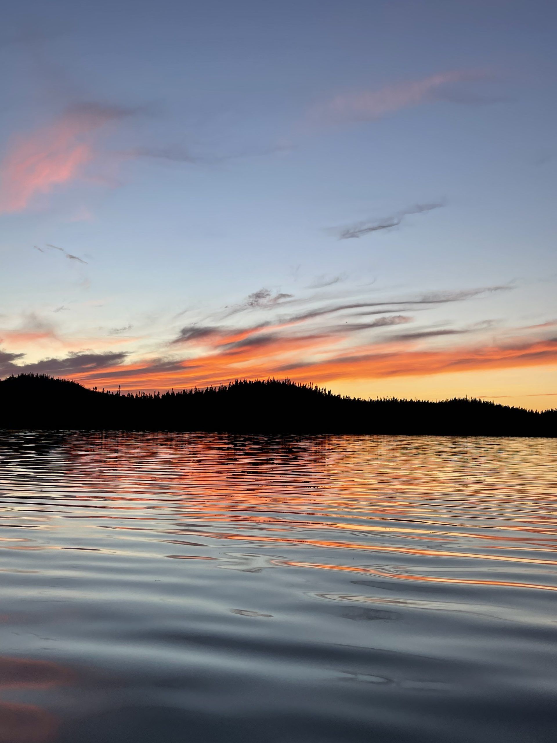 Un lac au coucher du soleil avec un ciel de coucher de soleil reflété dans l'eau.