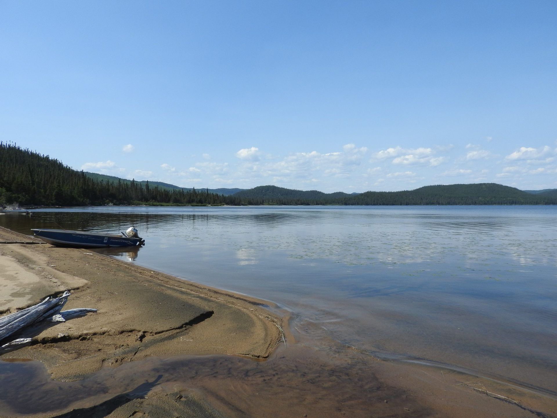 Un bateau est assis sur la rive d'un lac.
