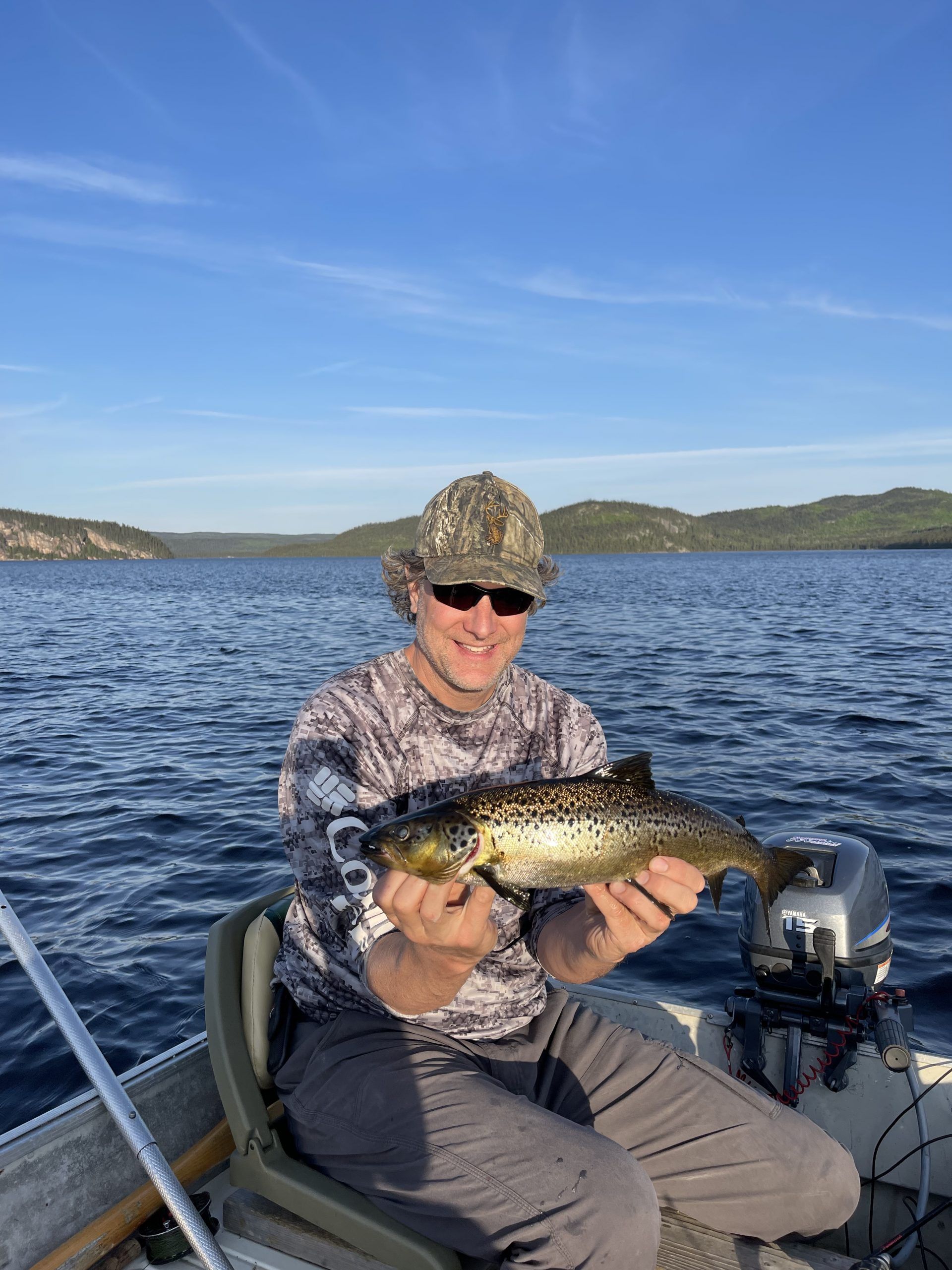 Un homme est assis sur un bateau tenant un poisson.