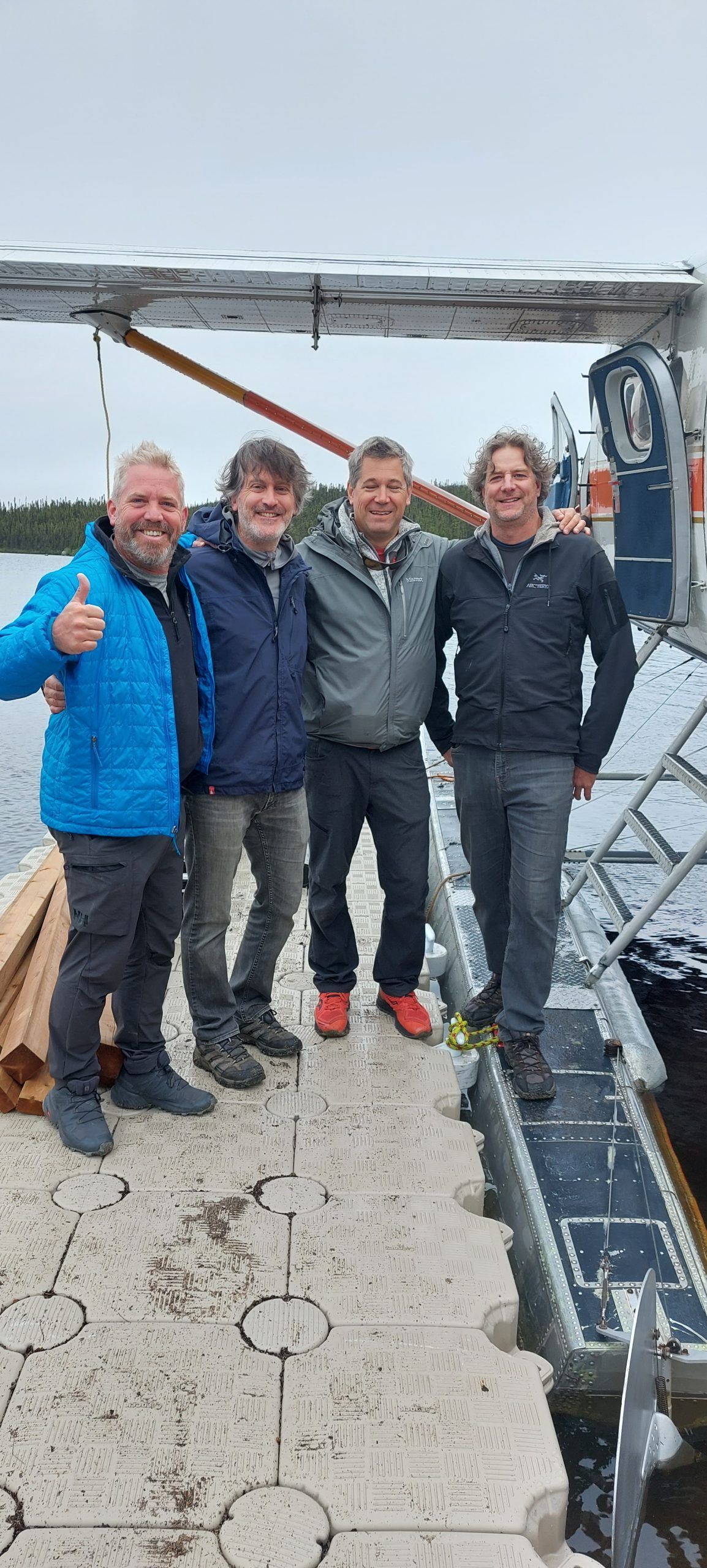 Un groupe d'hommes se tient sur un quai à côté d'un avion.