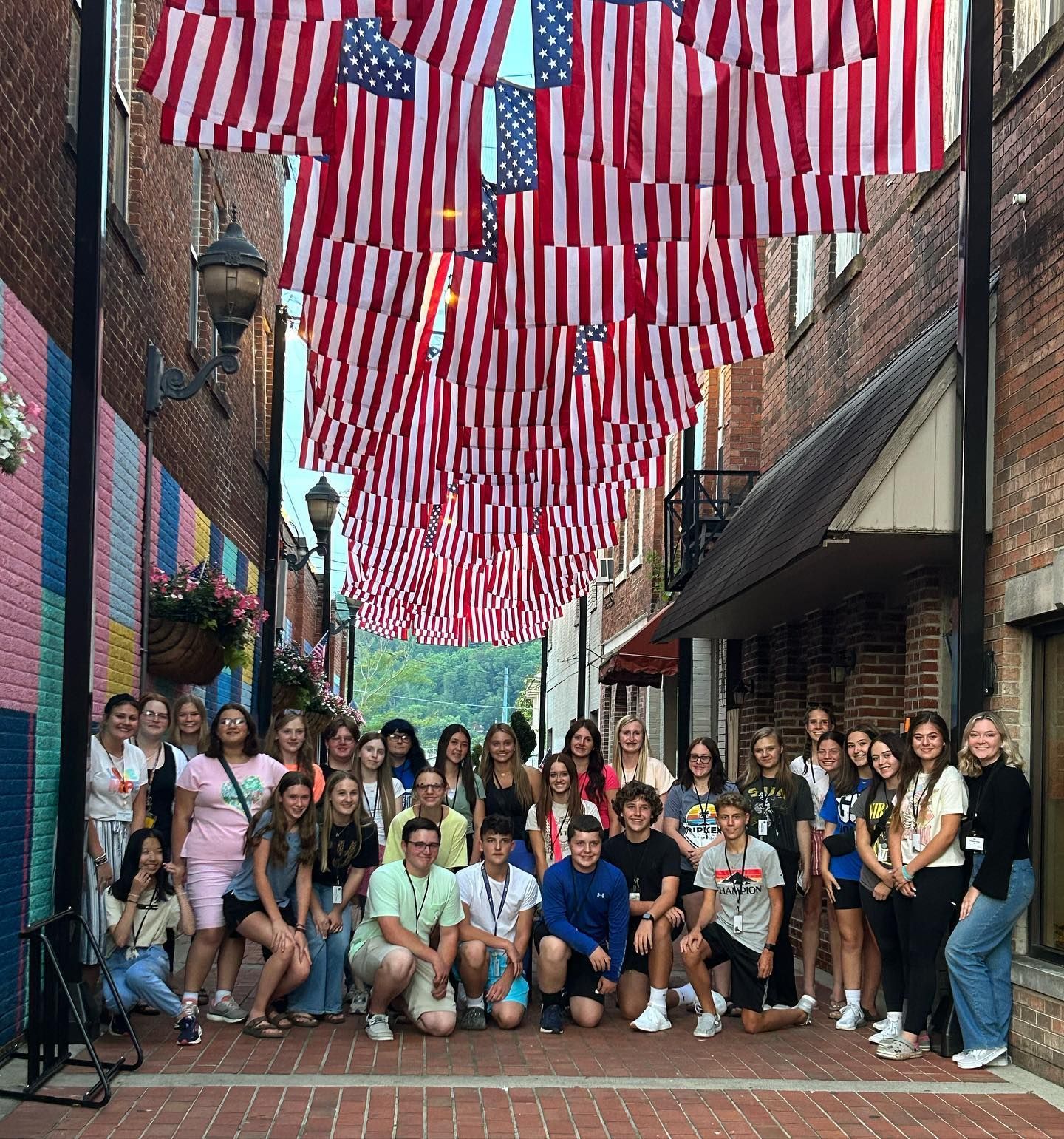 Rogers Explorers posing together down a Barbourville alley under several American flags.