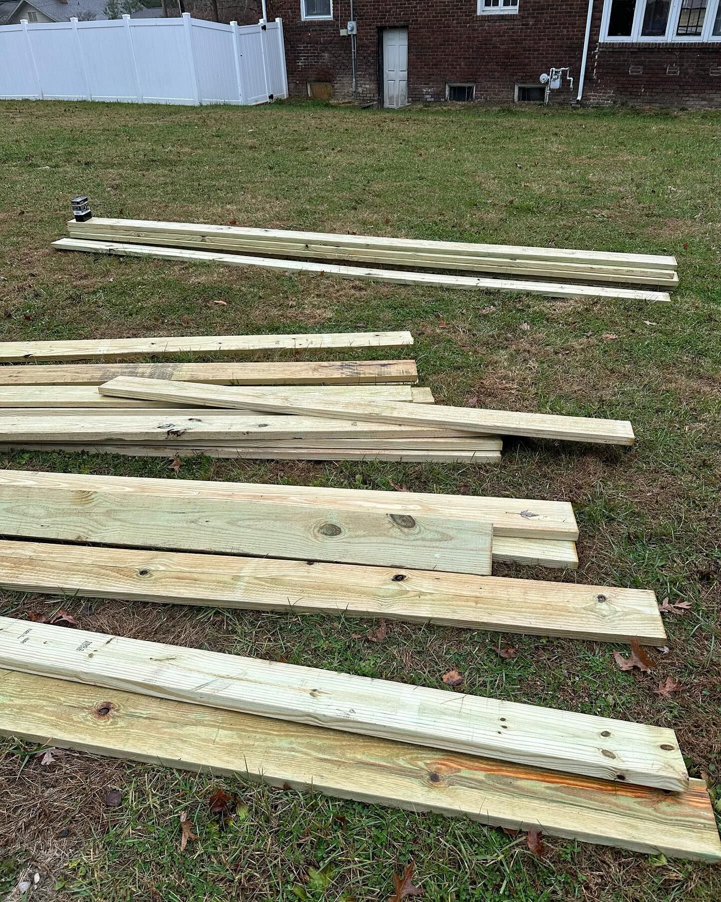 Wooden planks laid out on grass.