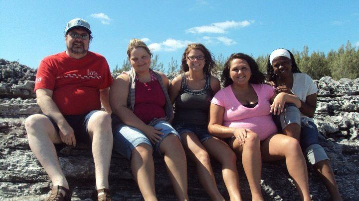 Miller sitting with a group of students outside during a field trip.