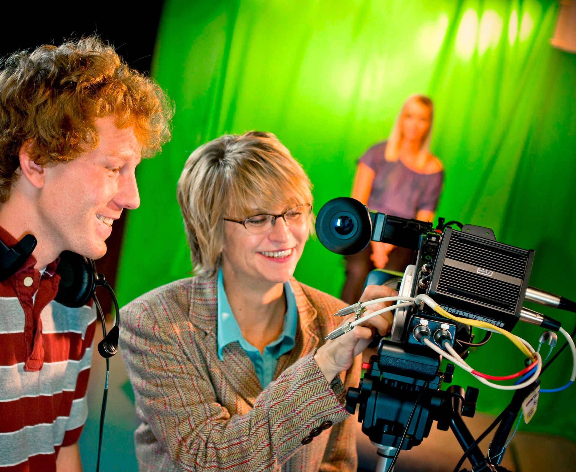 Dr. Christine Marley-Frederick teaching students how to use a camera in Union's production studio. A green screen can be seen in the background.