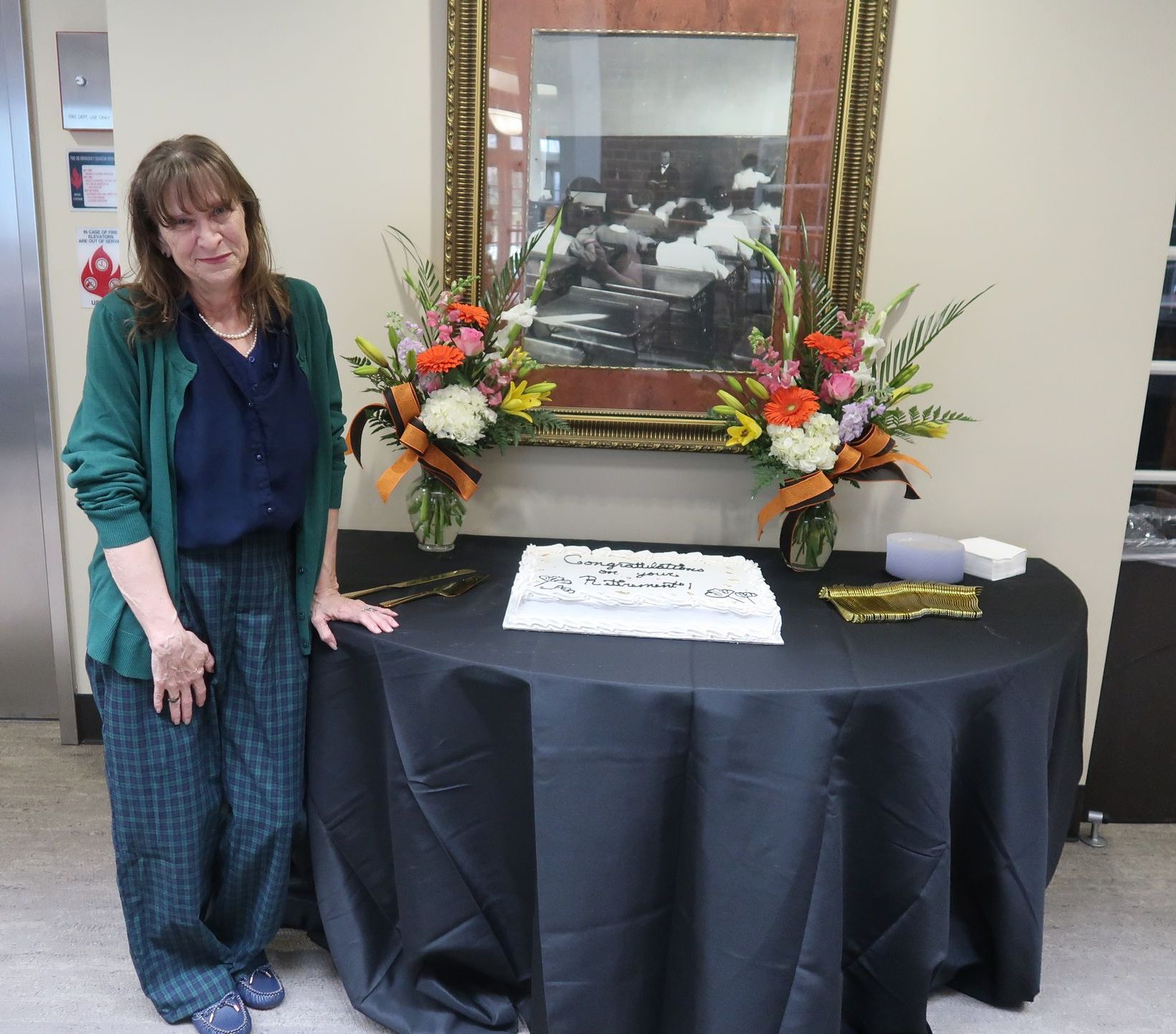 Dr. Christine Marley-Frederick standing beside her retirement cake.